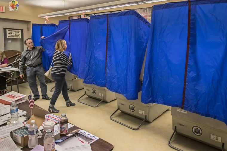 John Powell, left, the Judge of Elections for Ward 26, 4th Division, lifts the blue covering for a voter to enter the voting machine in the polling place at the bocci court at Marconi Plaza on Tuesday May 16, 2017. Voter turnout was low, around 30 as of noon. Polling place at Marcello Tenaglia Bocci Court in South Philadelphia at Marconi Plaza. Voters are heading to the polls today for Pennsylvania's primary election. 05/16/2017 MICHAEL BRYANT / Staff Photographer