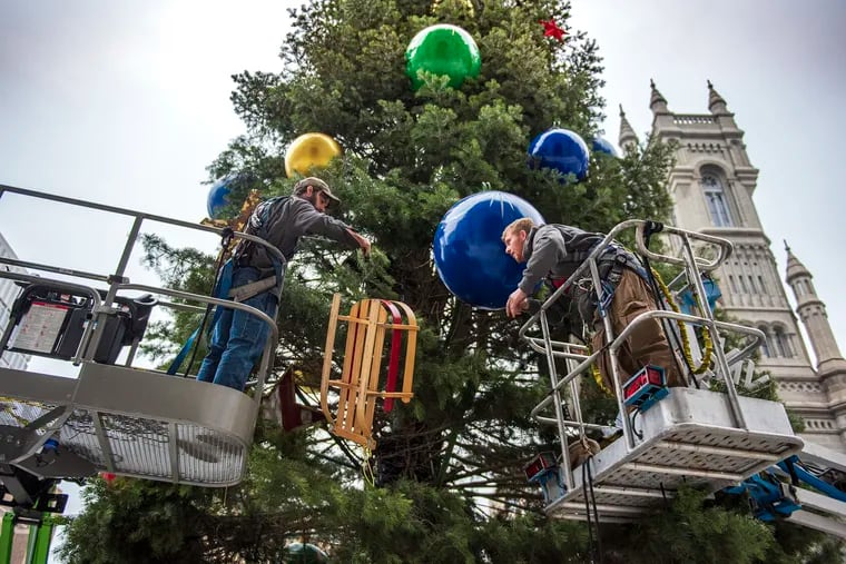 A crew from Proof Productions decorate the city's holiday tree at Philadelphia's City Hall with ornaments including colorful holiday balls, sleds, Christmas stockings, snowmen and snowflakes.