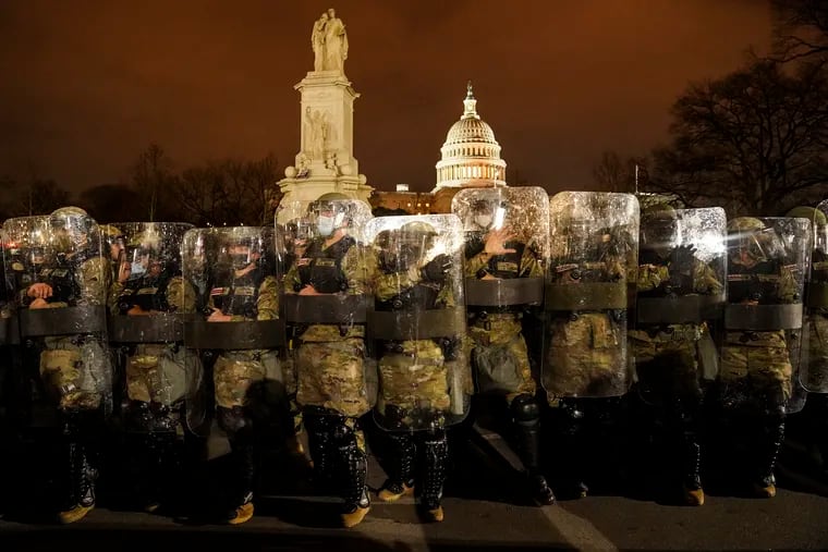 District of Columbia National Guard stand outside the Capitol after a day of rioting.