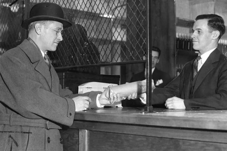 H.D. Fretz gets a bottle of alcohol at the State Store at 1225 Arch St. on Jan. 2, 1934, the day Pa. State Stores opened. (Temple Archives)