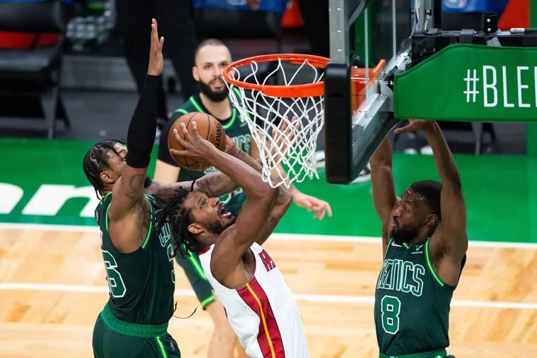 The Miami Heat's Trevor Ariza takes the ball to the basket against the Boston Celtics' Marcus Smart (36) and Kemba Walker (8) on Tuesday.