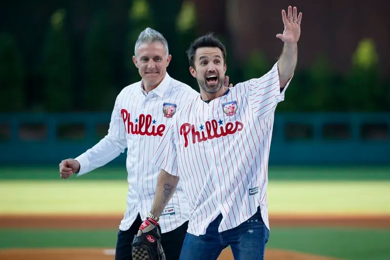 Actor Rob McElhenney (right) one of the creators of "It's Always Sunny in Philadelphia," reacts after catching a ceremonial first pitch from former Philadelphia Phillies player Chase Utley before a baseball game between the Phillies and the Miami Marlins on June 21, 2019.