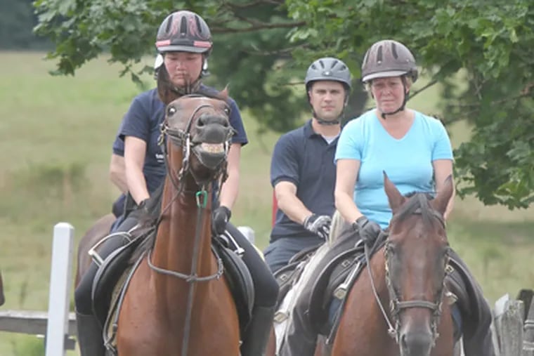 From left, Philadelphia Police Officers Chanthavy Hearn, Christopher Mulderrig, and Janice Petrone train in Ambler. The unit is coming back after disbanding in 2004. (Charles Fox / Staff Photographer)