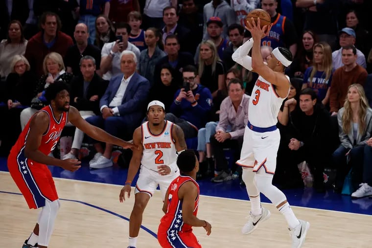 New York Knicks guard Josh Hart shoots a late fourth quarter three point basket over Sixers guard Kyle Lowry and center Joel Embiid in his team's Game 1 victory.