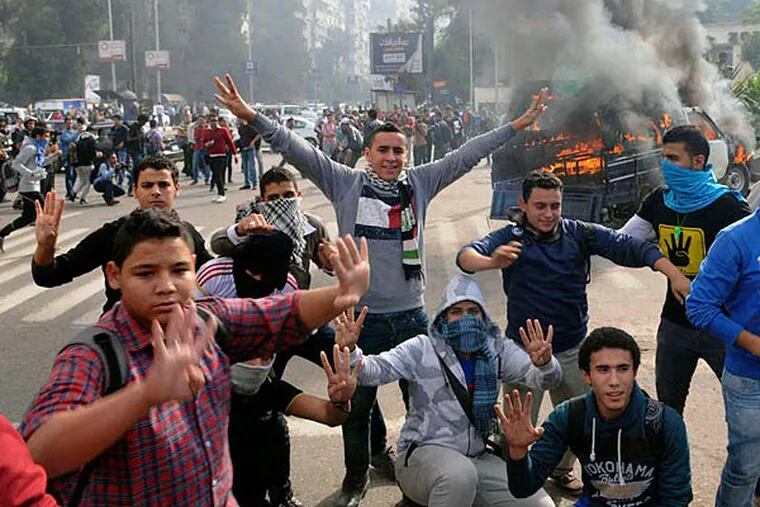 Student protesters making the four-finger sign that the Muslim Brotherhood and its allies have adopted to commemorate the victims of the crackdown, near Cairo University this month. (AP)