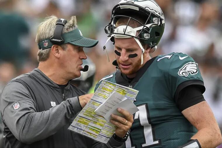 Eagles quarterback Carson Wentz and head coach Doug Pederson confer about a play along the sidelines during the game against the Arizona Cardinals at Lincoln Financial Field October 8, 2017. Eagles won 34-7. CLEM MURRAY / Staff Photographer