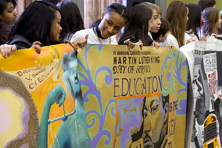 Taja Thornton, a 17-year-old senior at Cherry Hill West (2nd from left), along with students from six area schools proudly display the civil rights mural they painted to commemorate the upcoming 19th annual Greater Philadelphia Martin Luther King Day of Service at Girard College Jan. 8, 2014. 125,000 vounteers are expected to participate this year.  ( CLEM MURRAY / Staff Photographer )