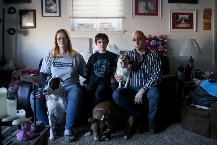From left, Vicki Berman; son, Hunter, 7; and husband, Alex Jay Berman, sit for a portrait with their dogs at their Northeast Philadelphia home on Friday, Jan. 11, 2019. The Bermans are both IRS employees who have been furloughed as a result of the ongoing government shutdown.