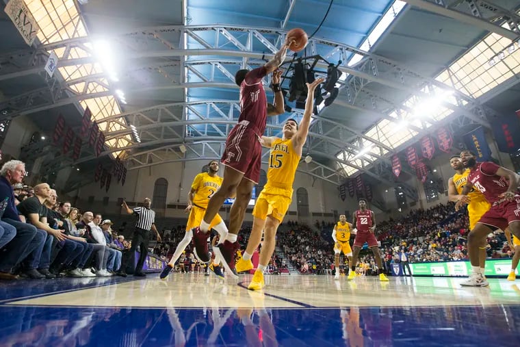 Nate Pierre-Louis, center, of Temple passes over Matey Juric, #15, of Drexel on Dec. 22, 2018 during the 2nd half at the Palestra.  CHARLES FOX / Staff Photographer