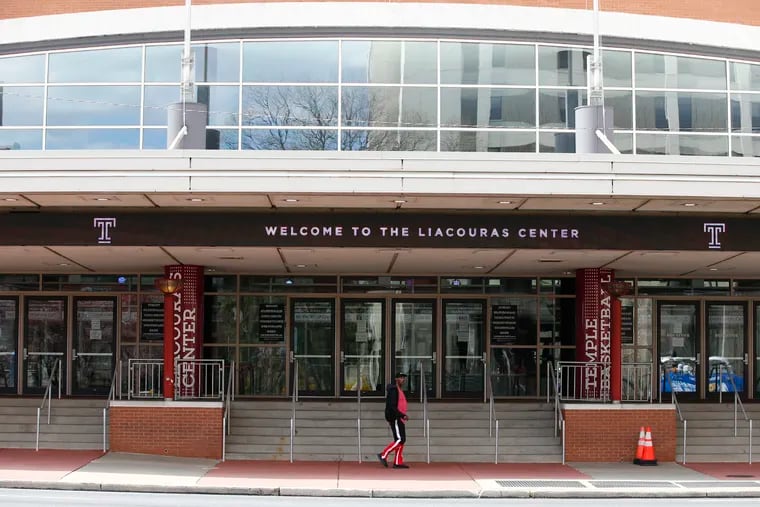 A pedestrian walks in front of the Liacouras Center at Temple University in North Philadelphia on Friday. Temple will allow the city to use the center for hospital space during the coronavirus pandemic.