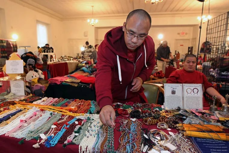 Tsultrim Dorjee, a monk from the Drepung Gomang Monastery in India,
arranges the necklaces and prayer bracelets on his table for sale at
the Tibetan Bazaar on Friday. ( Michael Bryant / Staff Photographer )