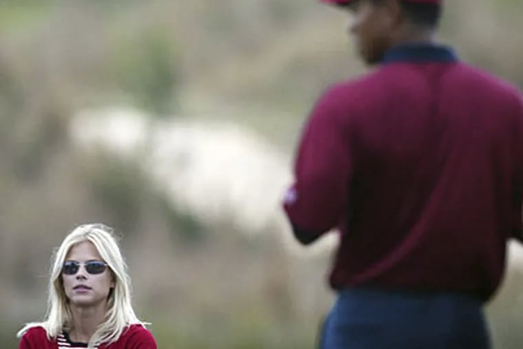 Tiger Woods, right, stands near his then-girlfriend Elin Nordegren, left, during the final day of the Presidents Cup in 2003. The now infamous crash has upended their marriage. (AP Photo/Themba Hadebe, File)