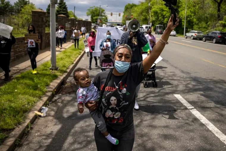 Asia Pratt, of Southwest Philadelphia, marches and leads activists along State Road near Curran-Fromhold Correctional Facility on April 30. Her husband was incarcerated there, and she was among families protesting jail conditions.
