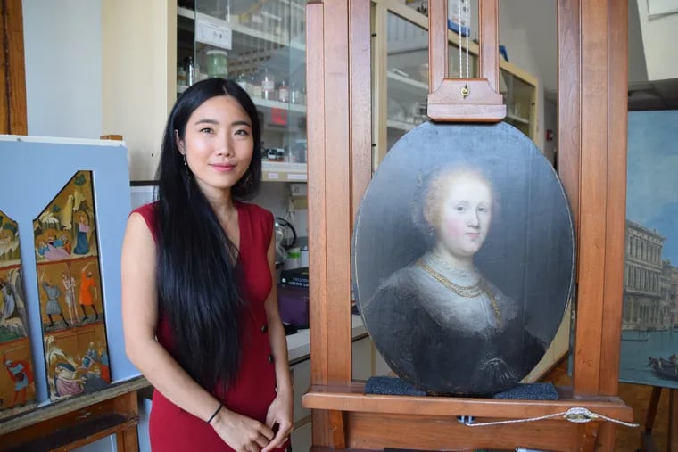 Conservator Shan Kuang with "Portrait of a Young Woman."