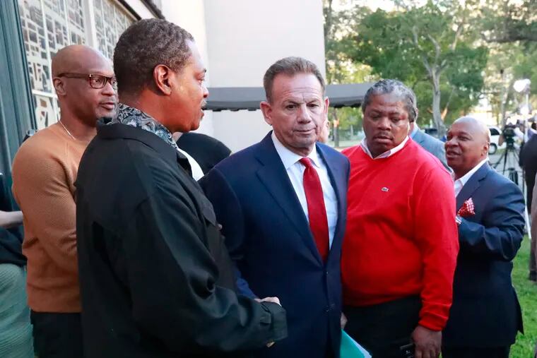 FILE- In this Jan. 11, 2019, file photo, suspended Broward County Sheriff Scott Israel (center) leaves a news conference surrounded by supporters in Fort Lauderdale, Fla., after Florida Gov. Ron DeSantis suspended him. Israel's lawyer says DeSantis' decision to suspend the sheriff who oversaw the response to the Parkland school shooting was a knee-jerk reaction based on politics. Those comments came Tuesday, June 18, 2019, at the beginning of a state Senate hearing as Scott Israel fights his suspension as Broward County sheriff.