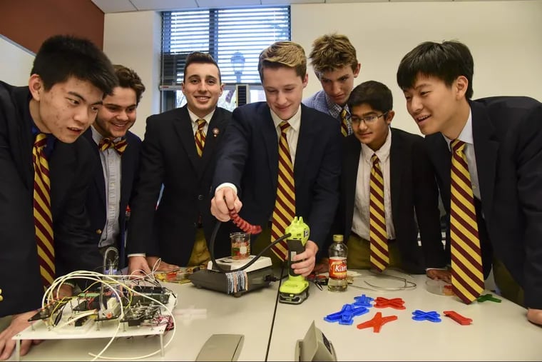 Haverford School senior Xavier Segel (center) is pneumatically actuating a gummy candy soft robotic arm for his fellow Soft Robotic Club members (from left) Ruhao Sun, Cal Buonocore, Matthew Baumholtz, Segel, Bram Schork, Aditya Sardesai and Yiheng Chen at the school November 7, 2017. Soft robotics is a new field which constructs robots from compliant rather than rigid materials, useful especially in the medical world. CLEM MURRAY / Staff Photographer
