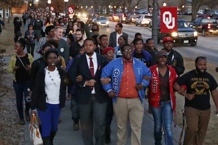 In this March 10, 2015, photo, University of Oklahoma students march to the now closed University of Oklahoma's Sigma Alpha Epsilon fraternity house  during a rally in reaction to an incident in which members of a fraternity were caught on video chanting a racial slur, in Norman, Okla. Many colleges are clamping down on campus fraternities after their reputations are sullied by race-tainted incidents. Even with a schools' sometimes swift and hard action, episodes such as the racist chants by members of the Sigma Alpha Epsilon chapter at the University of Oklahoma still surface.  (AP Photo/Sue Ogrocki)