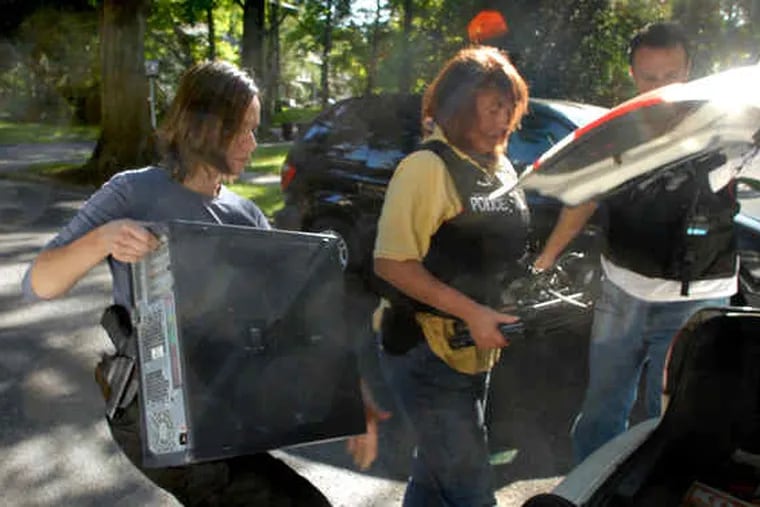 Investigators Lina Ramirez (left) of the FBI and Valerie Hecker of the county prosecutor's office put seized computers into the trunk of Kevin Kellejan's car.