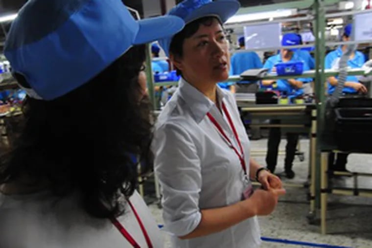 Terri Sun inspects the assembly floor of Phoenixtec Power Co. in Shenzhen, China, with a colleague, Xu Ye. Sun, who as a teen was banished to the countryside during Mao&#0039;s Cultural Revolution, works for the Cleveland-based multinational Eaton Corp.