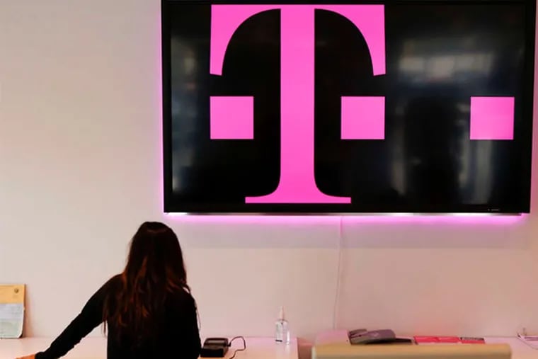 A T-Mobile employee transfers data to a new phone in Torrance, Calif. (Patrick T. Fallon / Bloomberg)