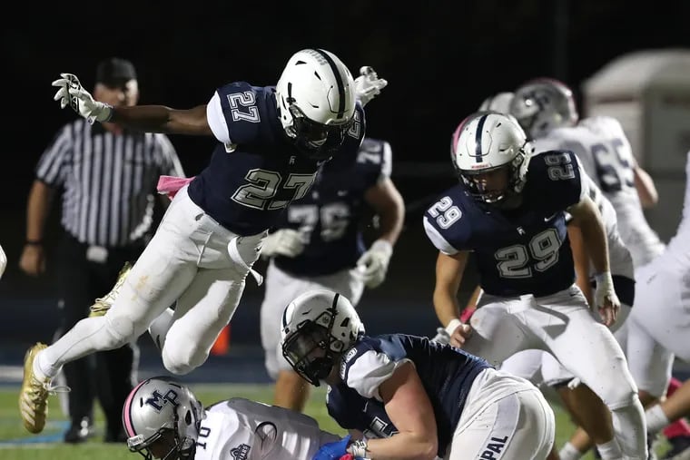 Malcolm Folk (top left) of Episcopal Academy flies over Lonnie White Jr. of Malvern Prep after White was tackled by Max Strid (center) during an Inter-Ac League football game Oct. 25, 2019.  Episcopal Academy's Matt Bush is at right.