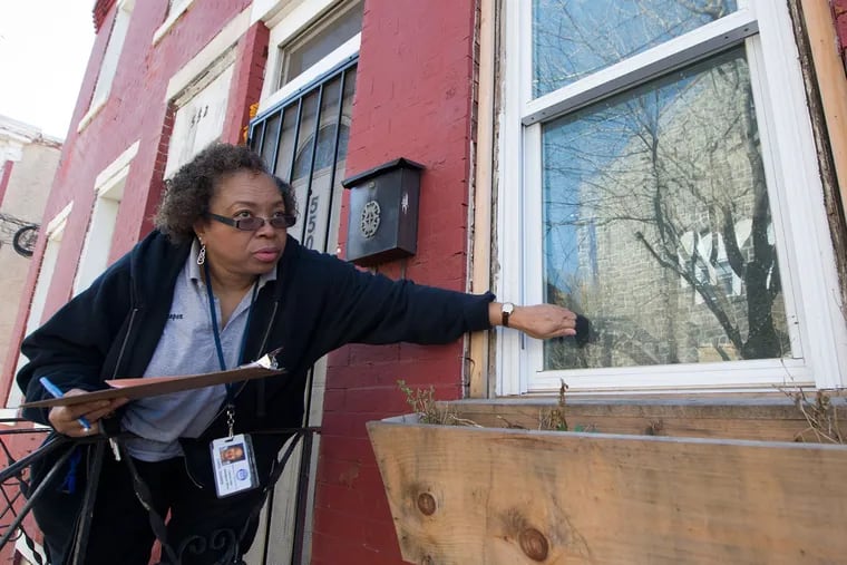 Camden School District attendance officer Carol Cooper, who works out of the High School, knocks on a window trying to talk with a parent or student about a truant student's reasons for missing school.
