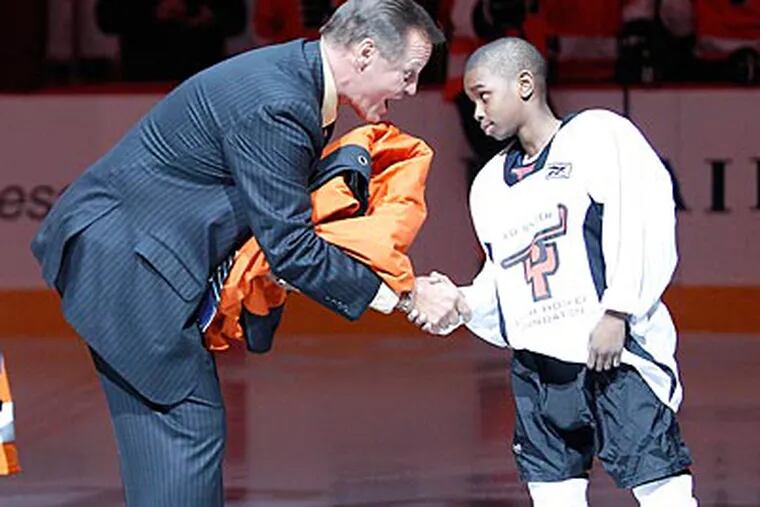 Former Flyer Bill Barber receives his banner from a member of the Ed Snider Youth Hockey Foundation. (Yong Kim/Staff Photographer)