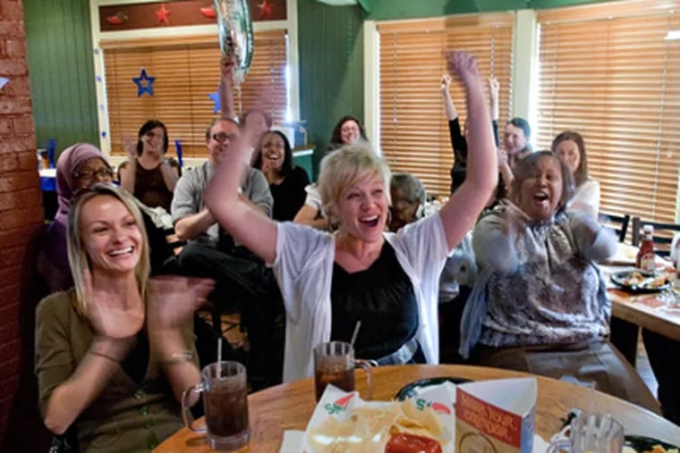 Cheering Mastery’s $1 million grant are staffers (center row, from left) Catherine Brand, Kim Crandall, April Thomas, Sharif El-Maki, and Krissy Kim. The group gathered at a Chili’s to watch the broadcast. (David M Warren / Staff Photographer)