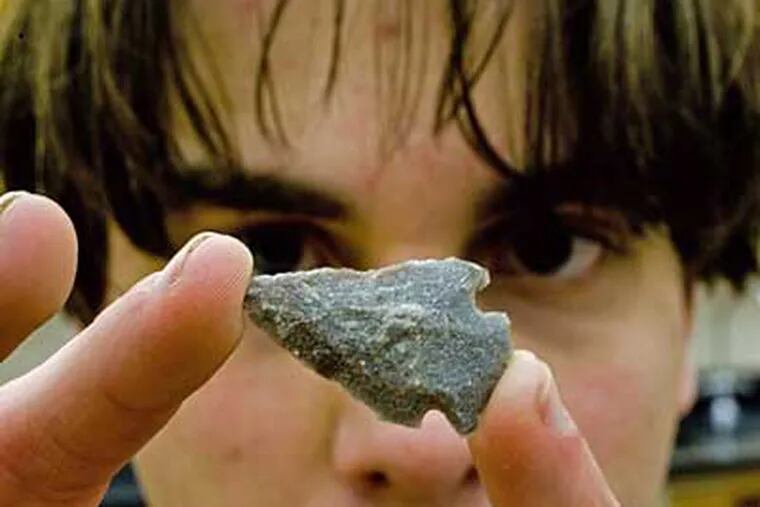 John Farrell, 17, a senior at Solebury School and son of teacher Lou Farrell, examines a projectile point from a selection being sorted for Brewerton Eared Points.  (David M Warren / Staff Photographer)