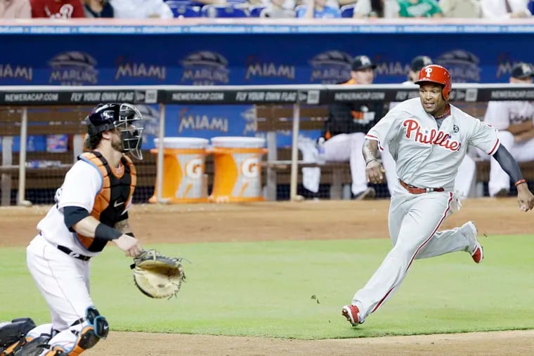 Marlon Byrd heads for home to score as Marlins catcher Jarrod Saltalamacchia waits for the throw on a single by Domonic Brown during the fourth inning.