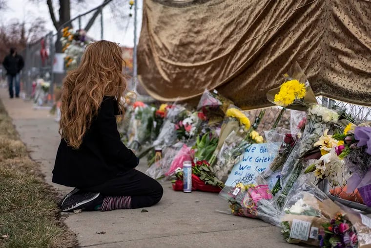 A mourner visits the location where a gunman opened fire at a King Soopers grocery store on Monday in Boulder, Colo. Ten people were killed in the attack.