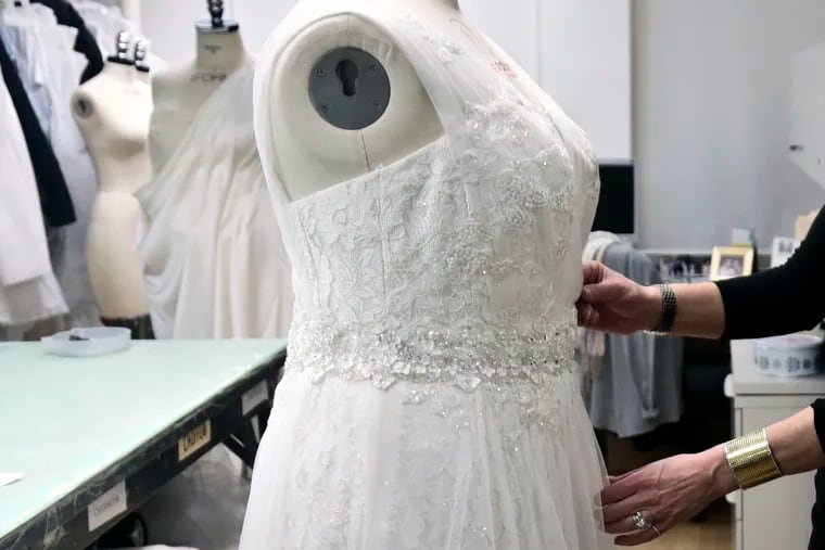In this 2013 file photo, a David's Bridal employee arranges a dress on a mannequin in New York.