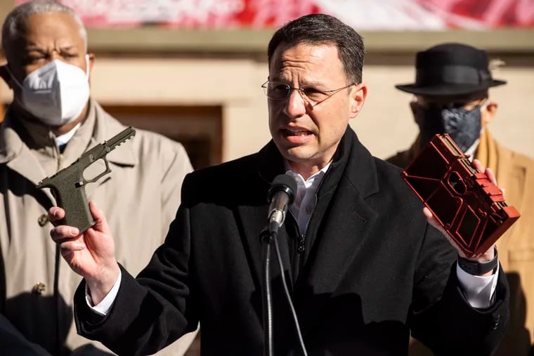 Pennsylvania Attorney General Josh Shapiro, holding up a ghost gun and an 80% receiver kit, announced Monday that Eagle Arms Productions, the largest gun show promoter in Pennsylvania, has halted the sale of 80% receiver kits at its gun shows. He was flanked by State Sens. Anthony Williams (left) and Vincent Hughes. State Rep. Amen Brown (D., Phila.) was also at the West Philadelphia news conference.