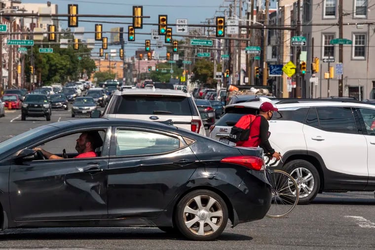 A bicyclist amid the cars at Ninth and Washington Avenue last week. The congested, dangerous roadway was due to be fixed this summer. City officials now say work to begin next year.