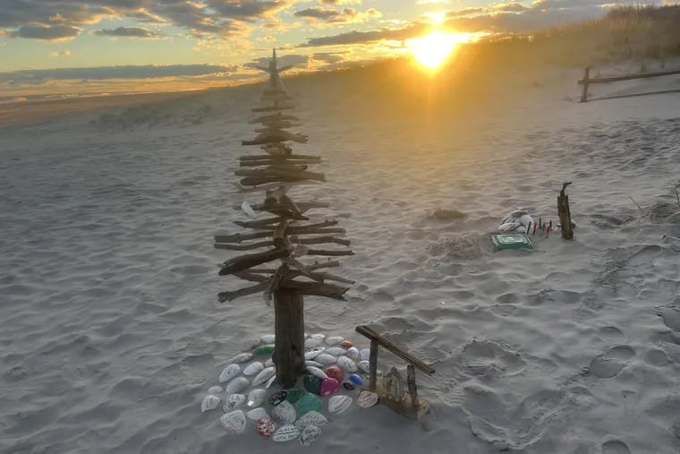 A Christmas tree sculpted of drift wood in the sand at 40th Street in Ocean City, N.J. Beach Christmas trees have proliferated in Jersey Shore towns, most lit with solar lights and often with their own themes.