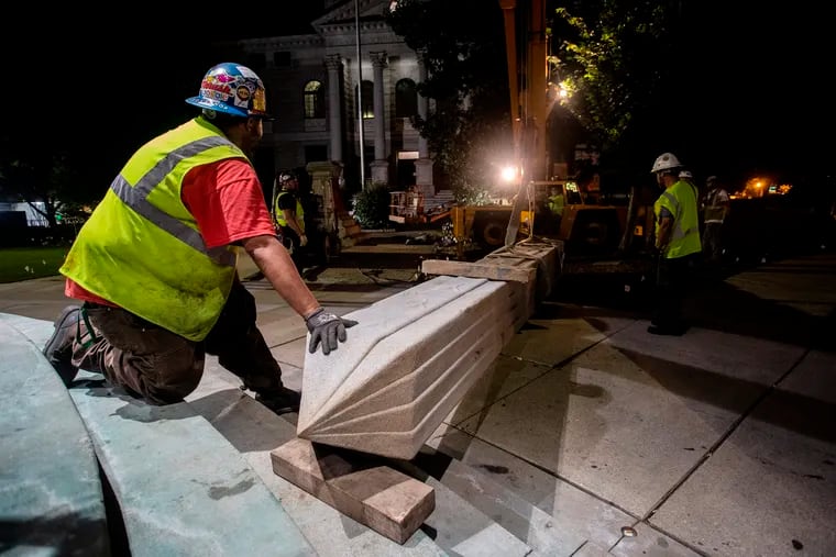 Workers secured a Confederate monument with straps after removing it from its base Thursday in Decatur, Ga. The 30-foot obelisk in Decatur Square, erected by the United Daughters of the Confederacy in 1908, was ordered by a judge to be removed and placed into storage indefinitely.