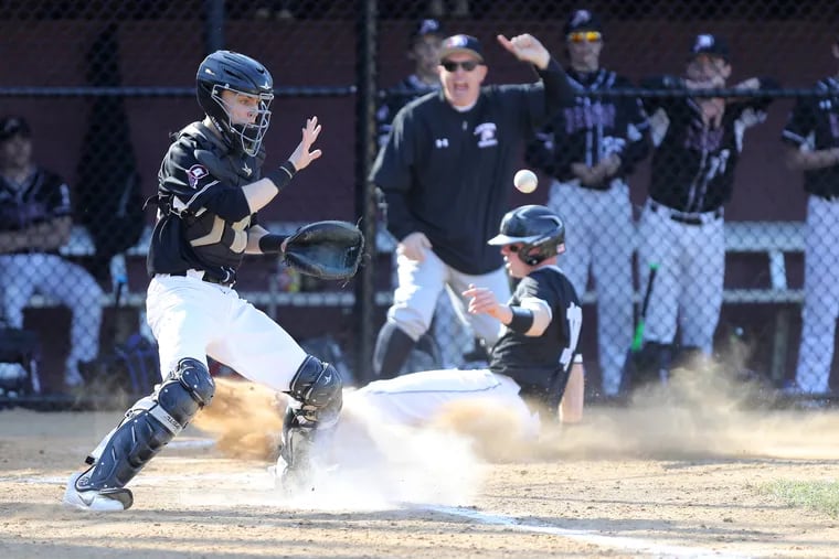 Brady Mutz, lower right, of Strath Haven scores on a sacrifice fly in the 3rd inning as catcher George Hoysgaard, left, of Radnor waits on the throw from the outfield on April 3, 2019.  Strath Haven won 7-4.