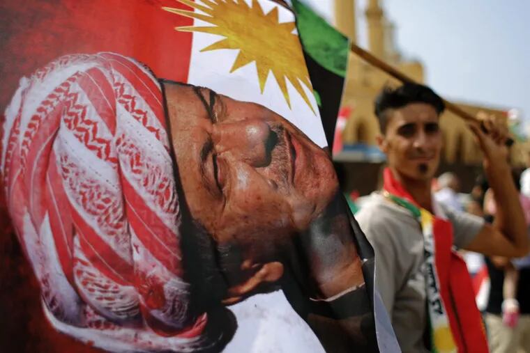 In Beirut, a man holds a Kurdish flag with a picture of Iraqi Kurdish leader Masoud Barzani during a gathering to support last month’s referendum.