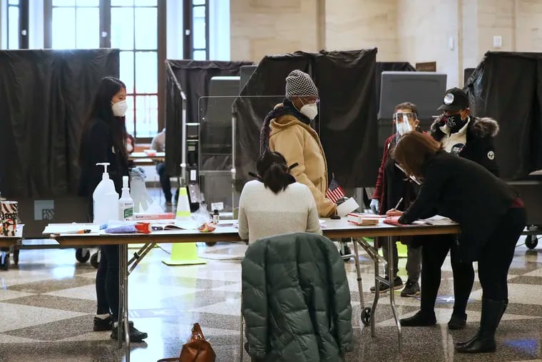 Poll workers assist voters inside the American Museum of the Revolution on Election Day.