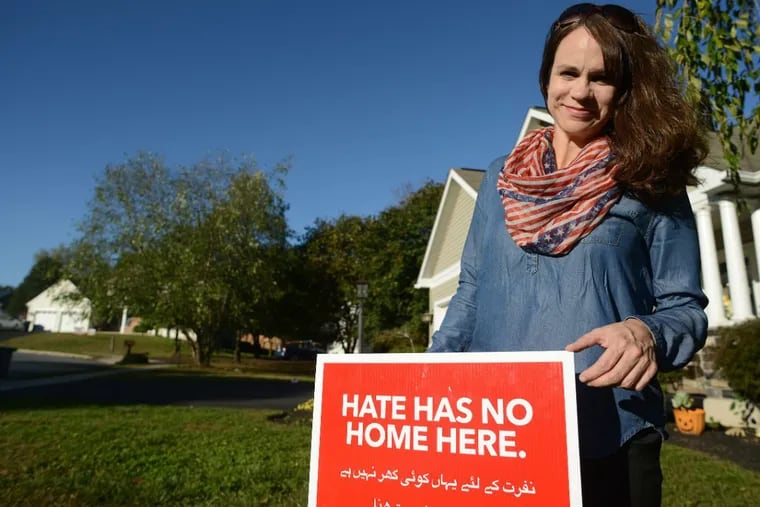 LaBrea Huff stands by the “Hate Has No Home Here” sign she planted in her front yard to combat the hate mail she has received Friday, Oct. 20, 2017, in Red Hill, Pennsylvania.