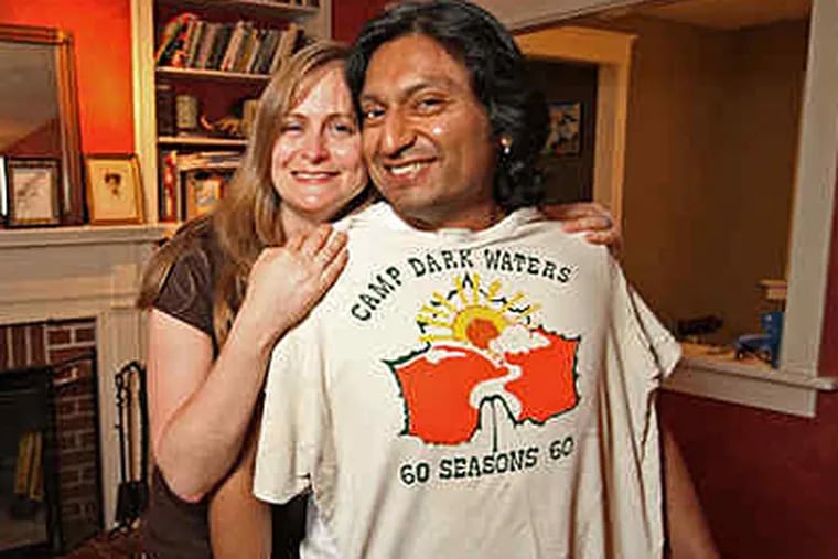 Amelia and Jorge Hamarman, who now live in Haddon Heights, show off a vintage T-shirt from their Camp Dark Water days. (Michael Bryant / Staff)