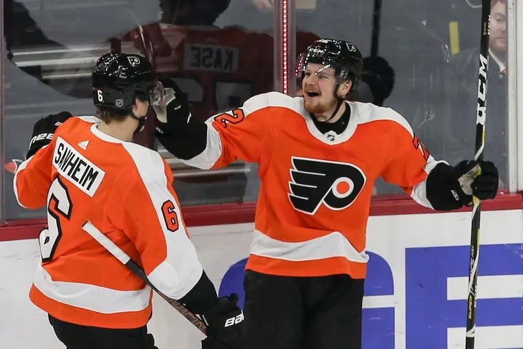 Flyers left winger David Kase celebrates the first goal in his NHL career Tuesday with teammate Travis Sanheim. The goal gave the Flyers a 2-0 second-period lead over Anaheim.