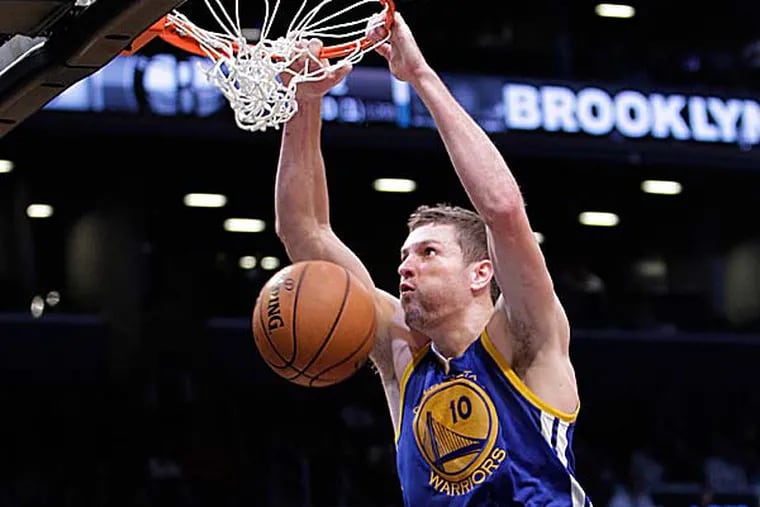 Warriors forward David Lee dunks the ball during the second half of their 109-102 win over the Nets. (Kathy Willens/AP)