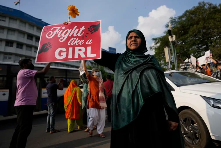 An Indian woman holds a placard as she participates in a march to mark International Women's Day in Bengaluru, India, Sunday, March 6, 2022.