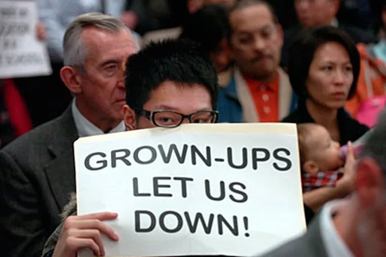 Students hold up signs in protest at a School Reform Commission meeting on Dec. 9.  (Sarah J. Glover / Staff Photographer)