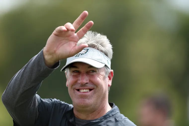 Eagles' head coach Doug Pederson waves to a fan during Eagles training camp in Philadelphia, PA on August 14, 2018. DAVID MAIALETTI / Staff Photographer