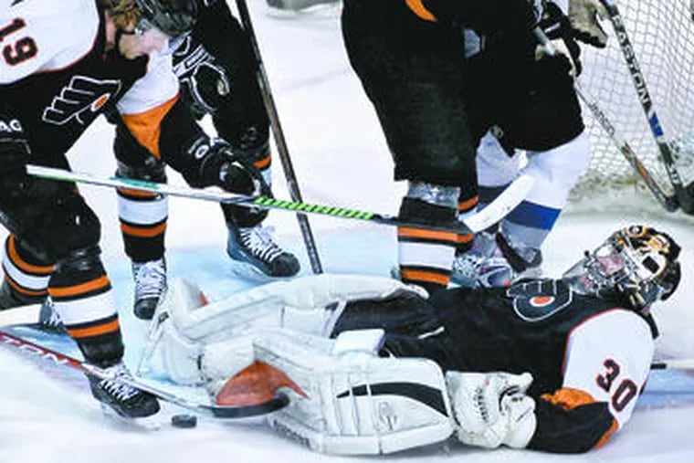 The Flyers&#0039; Scott Hartnell rides to the rescue, protecting the puck with his skate after the sprawled Antero Niittymaki lost sight of it.