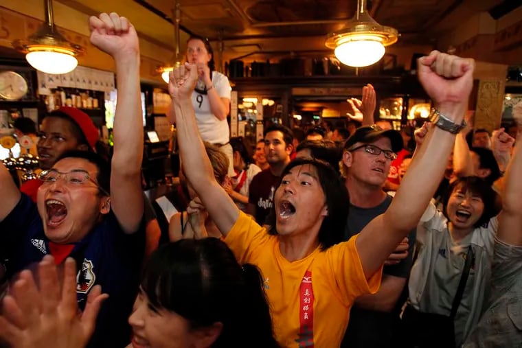 Fumio Takizawa, of Japan, center, celebrates the winning goal as soccer fans in Center City watch as Japan and the United States play in the women's World Cup Championship game. (David Maialetti / Staff Photographer )