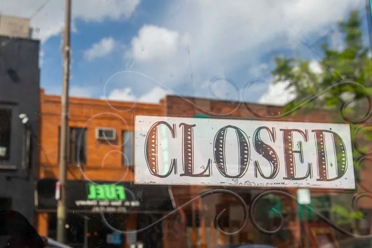 East Passyunk Ave. is defined by their small businesses and the possibility for home values to take a hit if these businesses don't reopen because of the coronavirus pandemic. A closed sign in Deja 42 front window with other stores reflected in the window on May 29, 2020.