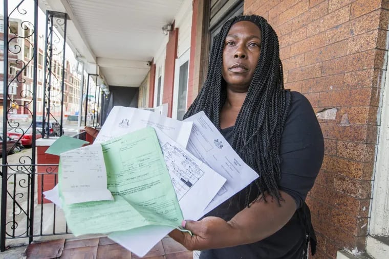 Tammy Hart-Barnes was set to go to court to resolve a dispute with a neighbor but did not appear because of, she says, confusion with the District Attorney’s Office. She displays the paperwork.